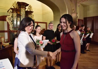 II. absolventský koncert, Refektář Profesního domu MFF, 14.5.2019. Paní ředitelka předává žákyni blahopřání k absolvování studia na ZUŠ.