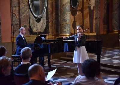 Adventní koncert ZUŠ 7.12.2019 - Klementinum. Pohled na pana klavíristu V. Kopáčika a děvče hrající na housle.