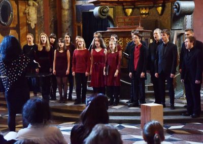 Adventní koncert ZUŠ 7.12.2019 - Klementinum. Pohled na publikum, zpívající sbor a paní sbormistryni M. Džunevu.