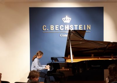Klavírní koncert D. Rolincové v C. Bechstein Pianocentru 23.01.2020. Žák hrající na klavír - chlapec.