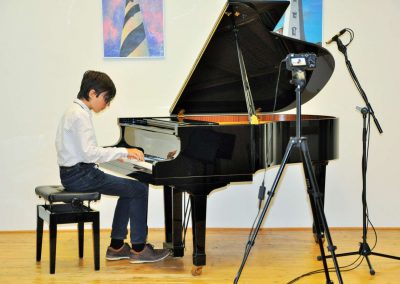 Natáčení absolventů, 24.6.2020, komorní sál ZUŠ Šimáčkova. Chlapec hrající na klavír.