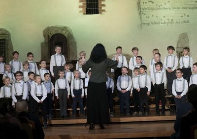 Adventní koncert Pueri gaudentes 9.12.2019 - Betlémská kaple. Pohled na sbormistryni M. Džunevu a zpívající chlapecký sbor.