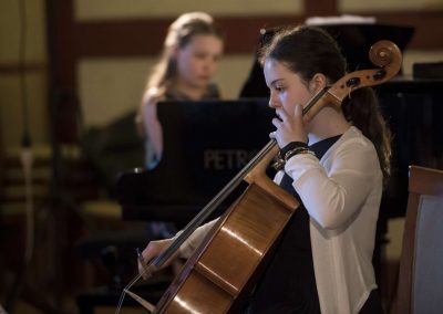 Dechový koncert, Profesní dům MFF, žačka hrající na violoncello.