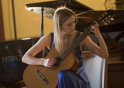 I. absolventský koncert, Profesní dům MFF, žačka hrající na kytaru.