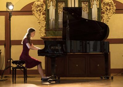 II. absolventský koncert, Profesní dům MFF, žačka hrající na klavír.