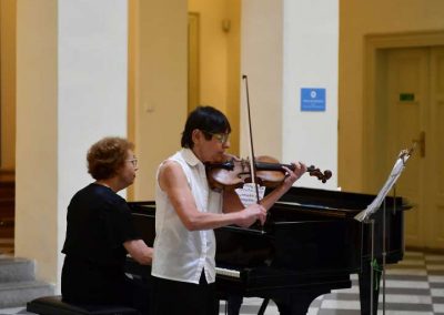 Koncert akademie pro seniory, České muzeum hudby, seniorka hrající na housle a paní učitelka doprovázející na klavír.