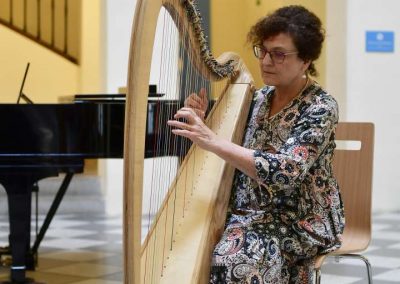 Koncert akademie pro seniory, České muzeum hudby, seniorka hrající na harfu.