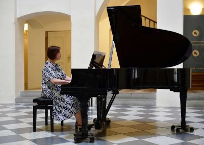 Koncert akademie pro seniory, České muzeum hudby, seniorka hrající na klavír.