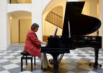 Koncert akademie pro seniory, České muzeum hudby, seniorka hrající na klavír.