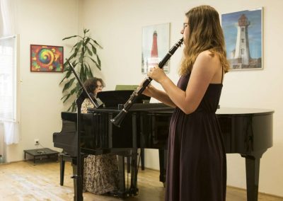 Školní absolventský koncert, komorní sál ZUŠ Šimáčkova, žačka hrající na klarinet a paní učitelka doprovázející na klavír..