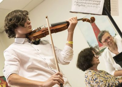 Školní absolventský koncert, komorní sál ZUŠ Šimáčkova, žák hrající na housle.