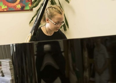 Školní absolventský koncert, komorní sál ZUŠ Šimáčkova, žačka hrající na klavír.
