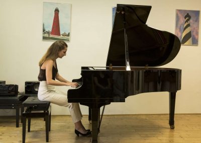 Školní absolventský koncert, komorní sál ZUŠ Šimáčkova, žačka hrající na klavír.