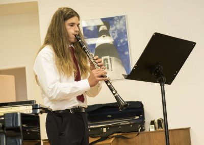 Školní absolventský koncert, komorní sál ZUŠ Šimáčkova, žák hrající na klarinet.