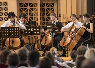 ZUŠ Open, HAMU, skupina žáků hrajících na violoncella.