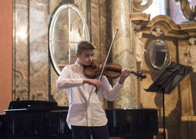 Adventní koncert v Klementinu, 10.12.2022, žák hrající na housle.