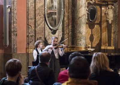 Adventní koncert v Klementinu, 10.12.2022, žákyně hrající na housle a paní učitelka doprovázející na klavír.