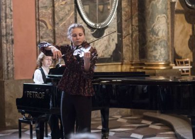 Adventní koncert v Klementinu, 10.12.2022, žákyně hrající na housle a paní učitelka doprovázející na klavír.