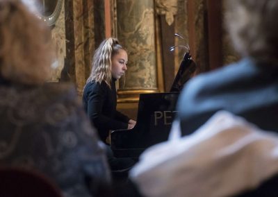 Adventní koncert v Klementinu, 10.12.2022, žákyně hrající na klavír.
