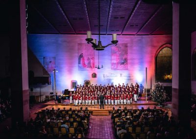 Vánoční koncert Pueri gaudentes, 19.12.2022, Betlémská kaple, Praha, zpívající chlapecký sbor a dirigující sbormistr.