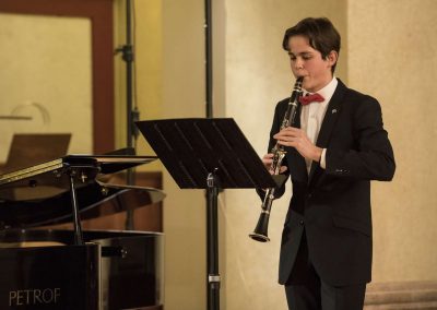 Dechový koncert, Profesní dům MFF, 27.2.2023, žák hrající na klarinet