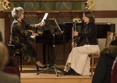 Dechový koncert, Profesní dům MFF, 27.2.2023, žákyně hrající na klarinet a paní učitelka