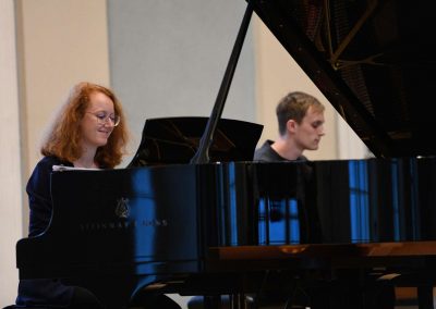ZUŠ OPEN sál Martinů HAMU, 24.5.2023, žáci hrající na dva klavíri.